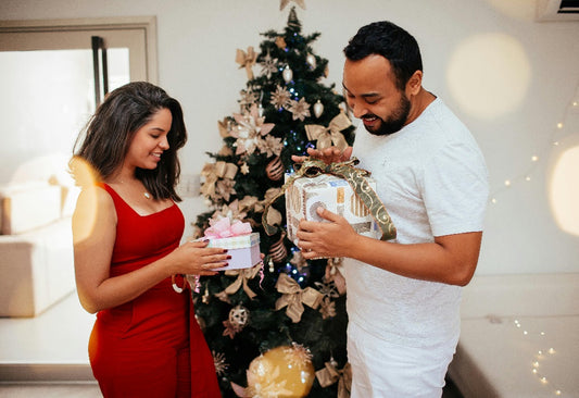 Pareja intercambiando regalos de Navidad en casa, última hora de regalos navideños